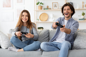 Emotional young family playing video games at living room