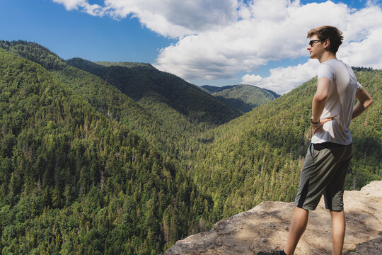 Young adult male enjoying beautiful view of ravine and forest of Slovak Paradise seen from Tomasovsky vyhlad (Tomasovsky view). Beautiful summer day, clean nature and tranquil scene