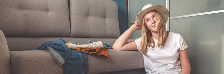 Travel. masked girl puts her things in a suitcase and dreams of rest, traveling after quarantine,...