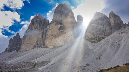Three peaks, drei zinnen with beautiful sunshine through the stony mountains in the italian dolomites, italy