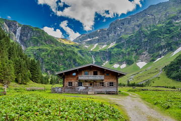 Wonderful austrian hut, house in the green mountains and stony rocks, alps of austria in the summer.