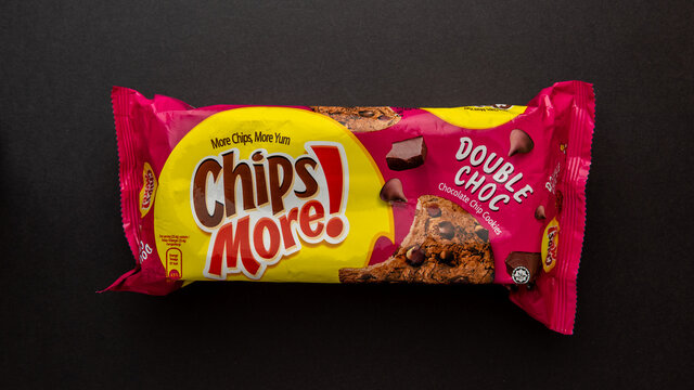 An isolated packet of Double Choc flavour of Chips More, a chocolate chip cookies, isolated on black background.