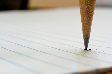 Close up of Broken #2 Pencil Lead on Lined White Paper .