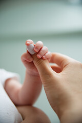 Naklejka premium newborn baby holding mom by finger, close-up