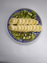 
a plate with banana slices and kiwi