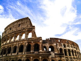 Fototapeta premium Photo of the Colosseum in Rome dominated by clouds in a blue sky