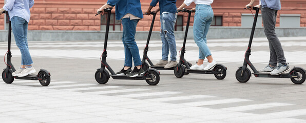 Five friends having ride on motorized kick scooters - obrazy, fototapety, plakaty