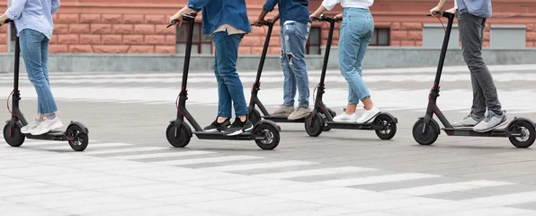 Foto op Plexiglas Five friends having ride on motorized kick scooters © Prostock-studio