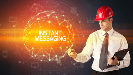 Handsome businessman with helmet drawing INSTANT MESSAGING inscription, social construction concept