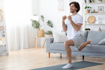 Young handsome guy working on his muscles at home