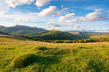 beautiful carpathian countryside. sunny afternoon. wonderful autumn landscape in mountains. rural scenery with agricultural fields on rolling hills. watershed ridge in the distance