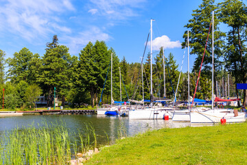 Fototapeta na wymiar Catamaran sailing boats on lake Beldany in Piaski port on summer sunny day, Mazury Lake District, Poland