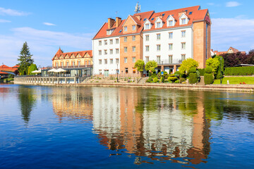 Obraz premium Reflection of historic buildings in Pisa river in Pisz town, Masurian Lakes region, Poland