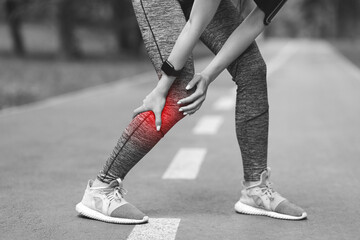 Sport Trauma. Female jogger with injured calf massaging painful leg muscle outdoors