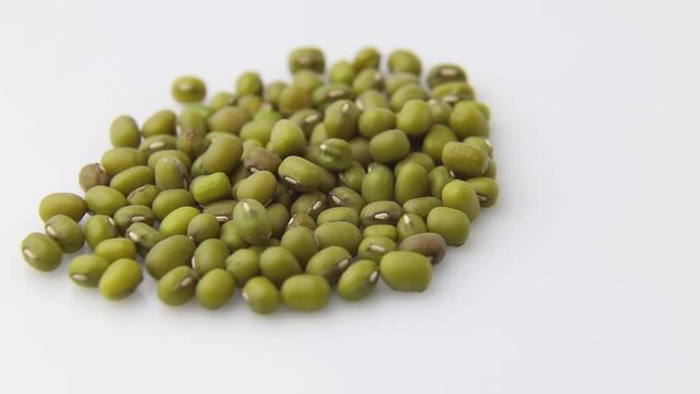 Rotating of mung beans on white background. Side view, close up.