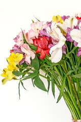 Alstroemeria bouquet of flowers in a vase by the window. Beautiful bouquet of colorful flowers in the apartment by the window.