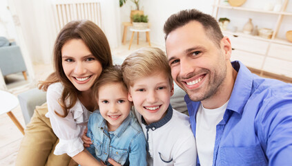 Obraz premium Happy Parents And Children Smiling Posing To Camera At Home