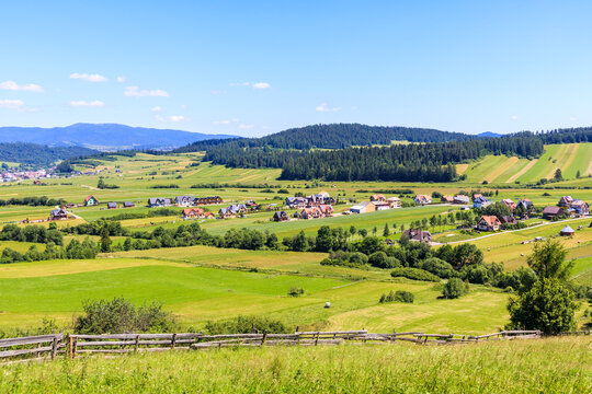 Green farming fields and view of Kacwin village in Tatra Mountains on beautiful summer sunny day, Poland