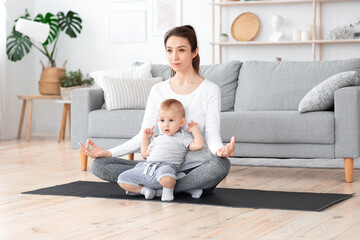 Releasing Stress in Motherhood. Young Mom Meditating At Home With Baby On Laps