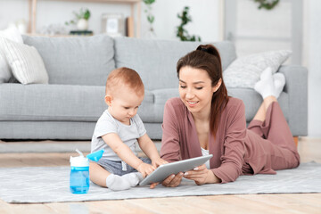 Young Mom And Her Baby Son Playing Delevelopment Games On Digital Tablet