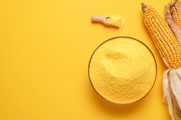 Cornflour in a bowl top view. Bowl with polenta isolated on yellow background.