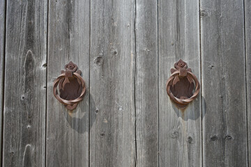 antique wooden gate with vintage handles. A faded, shabby tree. Interesting image for background or...