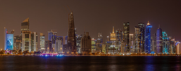Fototapeta na wymiar Doha Qatar skyline at night showing skyscrapers and lights reflected in the Arabic gulf