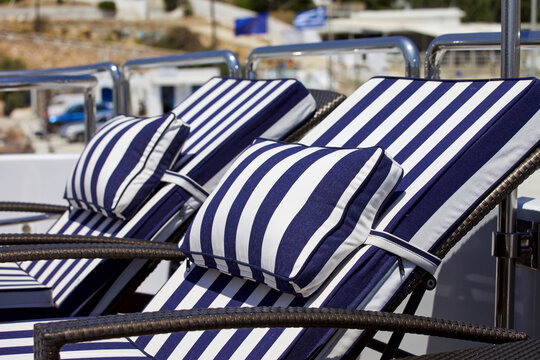 Luxury yacht Loungers. Isolated.Blue and white striped loungers on deck of yacht. Focus in the front. Stock image.