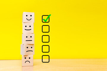 Customer service evaluation and satisfaction survey concepts. Images of emoticons on wooden cubes....