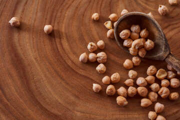 Superfood chickpeas lie in wooden background with spoon. Close-up. Top view.