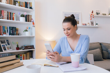 Young woman working at home and using mobile phone