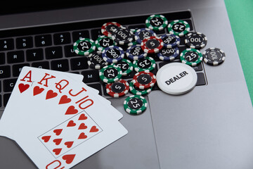 Poker cards and stacks of poker chips on a laptop computer. Poker online concept.