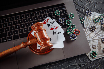 Judge's wooden gavel, poker chips and playing cards. Concept of Law and regulation of gambling.