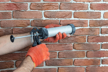 Grouting decorative gypsum brick with white cement grout. Applying grout with a syringe.