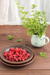 Red fresh raspberries on brown rustic wood background. Bowl with natural ripe organic berries on wooden table