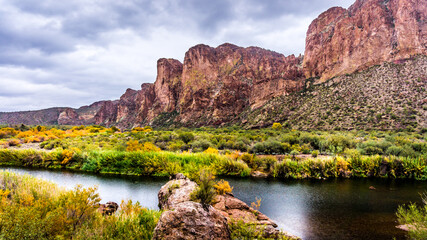 The Salt River and surrounding mountains with fall colored desert shrubs in central Arizona, United...