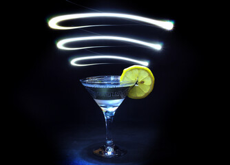 Glass of cocktail in a dark room and neon light trails