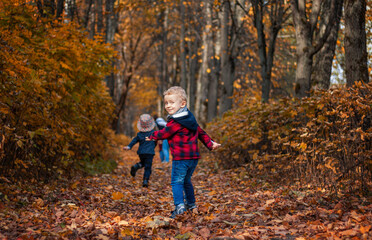 group of Caucasian preschoolers children in stylish clothes run in the autumn park. For various design purposes. Go ahead for the autumn discounts on the children's collection