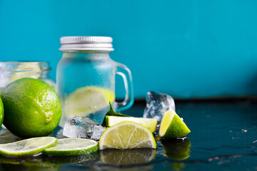 green lime Set of fresh whole and cut and slices, lime fresh water and cocktail - summer cool background