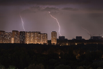 Silhouette of the night city. Lightning over the city. Storm over a residential area. lightning...