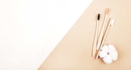 Three dental bamboo brushes on white background with flower of cotton