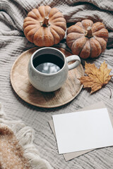 Obraz na płótnie Canvas Fall styled composition. Autumn breakfast still life. Blank greeting card mock-up scene with cup of coffee, wool blanket, maple leaf and pumpkins. Cotton table cloth background. Thanksgiving. Vertical