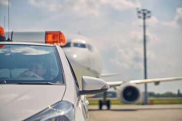 Fototapeta na wymiar Civil airplane following an airport ground vehicle