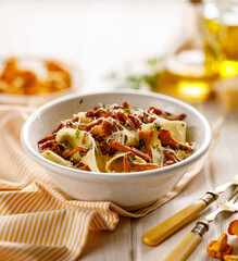 Pappardelle pasta with chanterelle mushroom and fresh parsley sprinkled with grated Parmesan cheese close up view