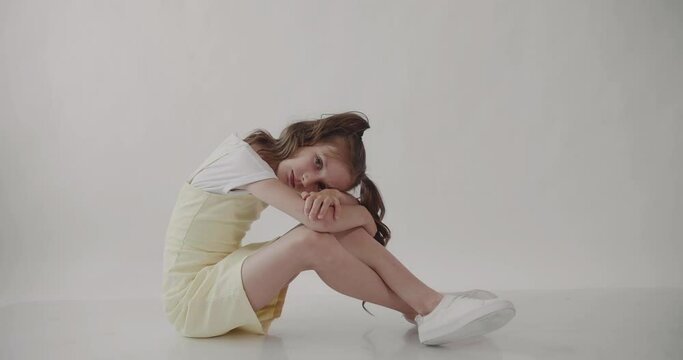 Upset girl sits with her head on her knees. Deadly embrace. deadlocked situation