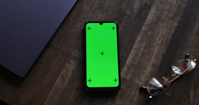 Top View, Smart Phone Place On Table Wood With Green Screen And Tracking Dots, Close-up The Cell Phone Is On The Brown Desktop With Chroma Key, Green Screen Telephone, Slider And Top View.