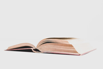 Large old hardback book sitting open, showing worn pages inside, isolated on a white background