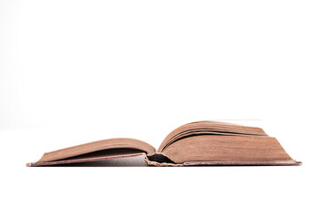 Large old hardback book lying open showing worn pages inside, isolated on a white background