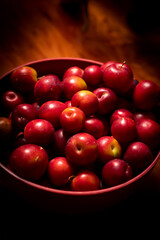 Red plums in a red bowl on a wooden bench