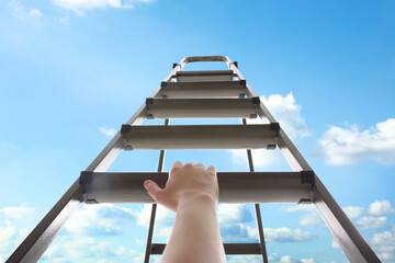 Woman climbing up stepladder against blue sky with clouds, closeup - obrazy, fototapety, plakaty